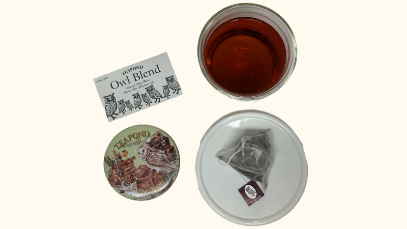 ティーポンドのアウルブレンドの紅茶缶と説明カードと茶葉と淹れた紅茶