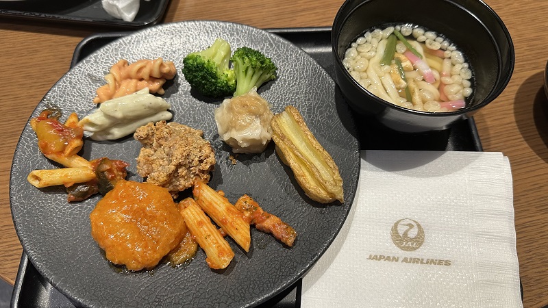 羽田空港第3ターミナル サクララウンジの取り分けた料理と温かいうどん